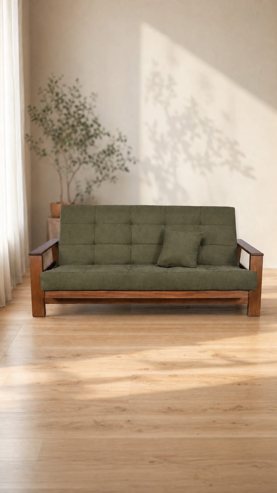 Sofá cama Montana en verde olivo, con descansabrazos de madera maciza, en una sala de piso de duela
